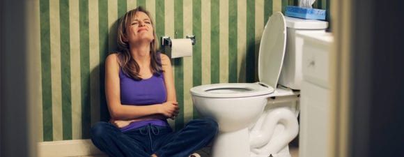 Woman with sitting next to toilet. dealing with constipation, one of the Fatal Five conditions