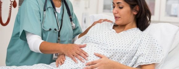 doctor examining pregnant woman's belly