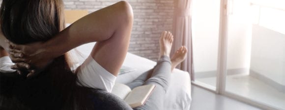 woman relaxing and reading with legs up
