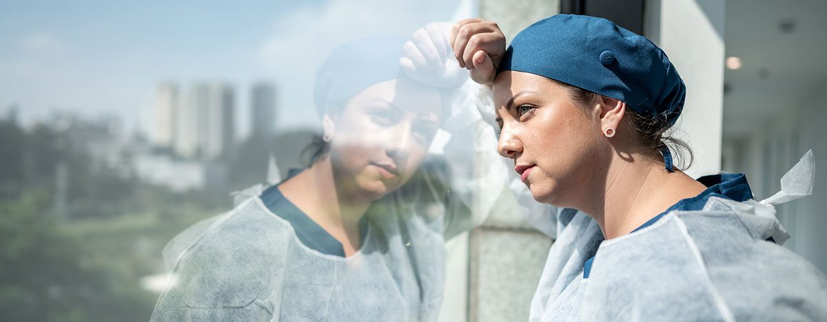 A stressed clinician shows the critical need for preventing burnout in healthcare.