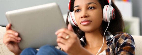 woman wearing headphones looking at tablet