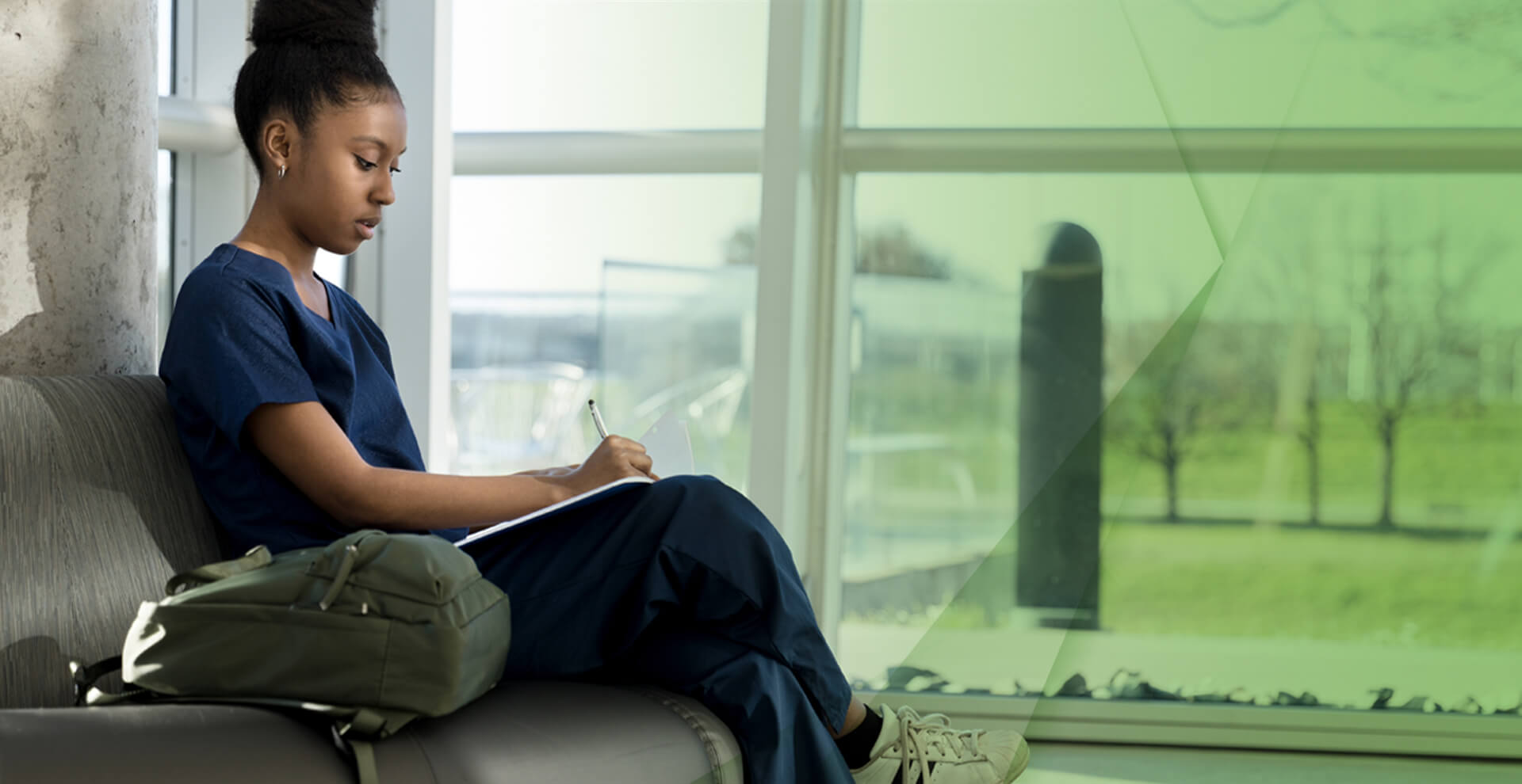 A young nurse writes notes while sitting on a bench