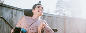 a boy smiles in a wheelchair
