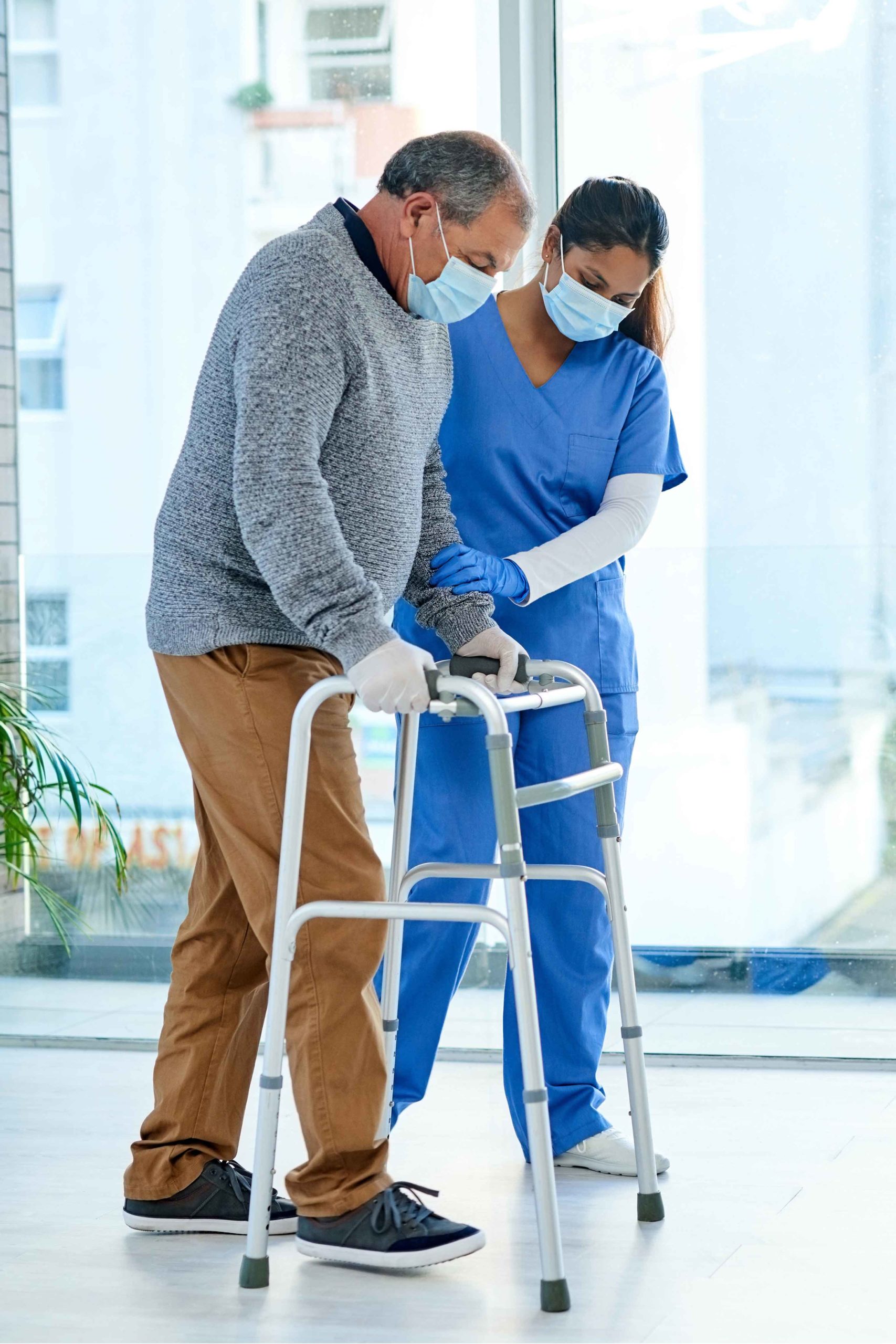 man using walker with nurse