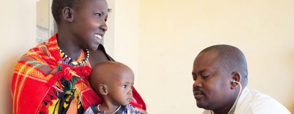 A mother and baby are seen by a healthcare provider in Kenya