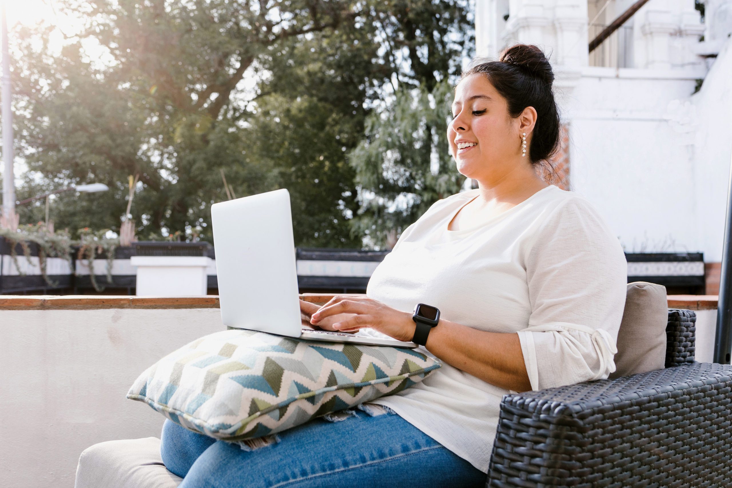 woman sitting outside working on laptop