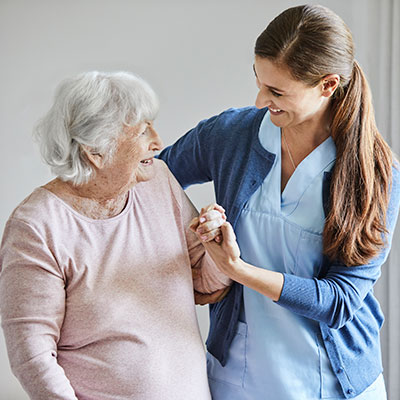Nurse assisting an older female patient