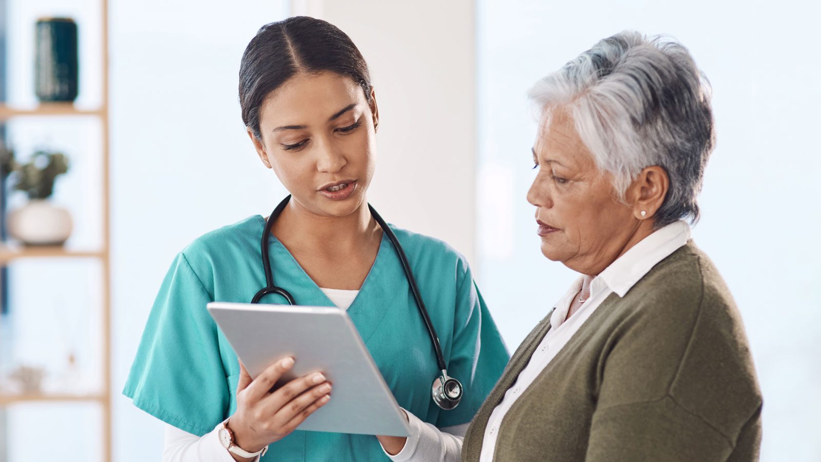 two healthcare professionals discuss results on a tablet