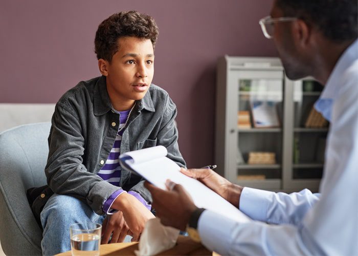 Therapist working with a teenage boy using CBT techniques for kids