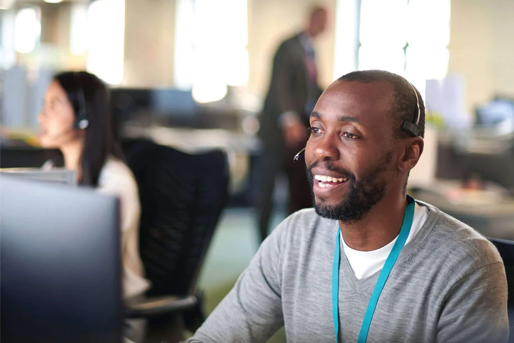 man smiles working at computer