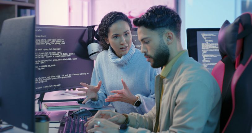 A Native American woman IT developer speaks to a co-worker