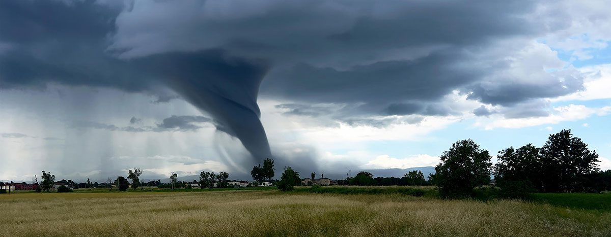 A tornado's funnel cloud touches down on a plain