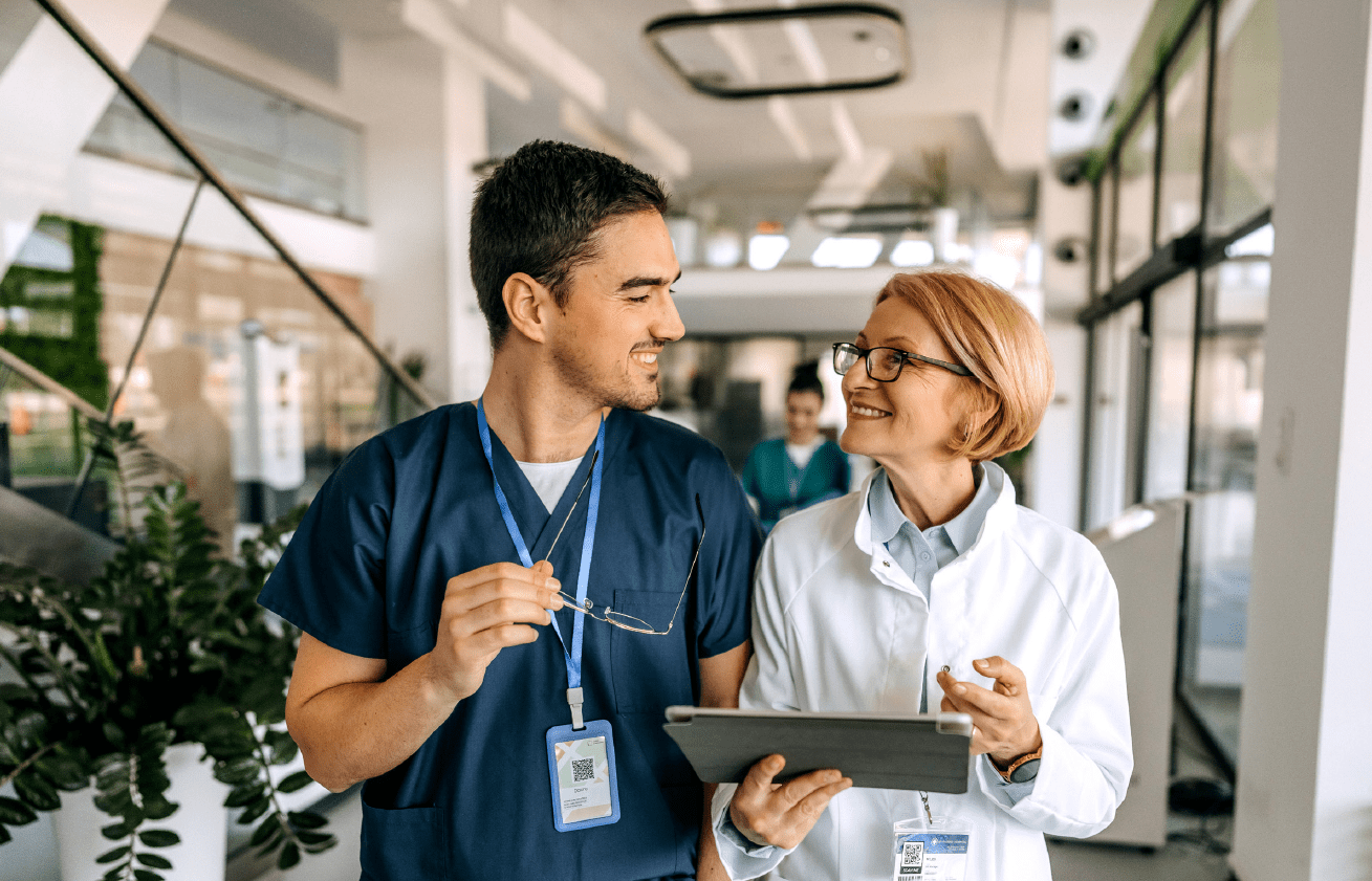 https://www.relias.com/wp-content/uploads/2025/07/AMB-doctor-and-nurse-in-hall-with-tablet.png